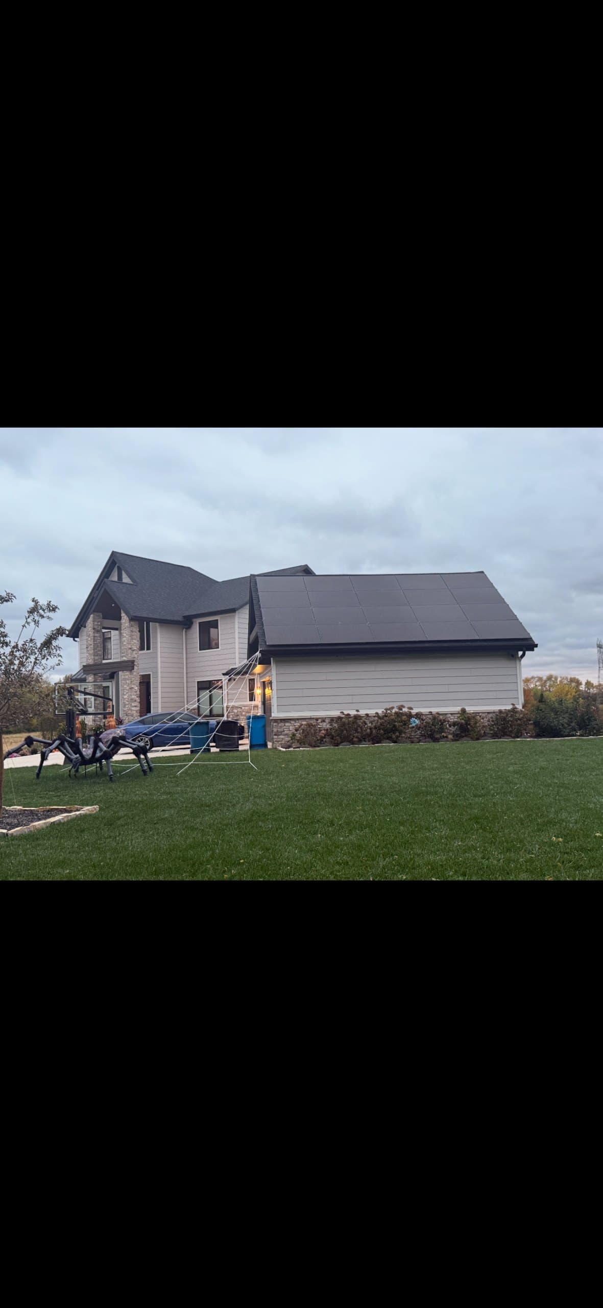 Large two-story home with solar panels on the garage roof section